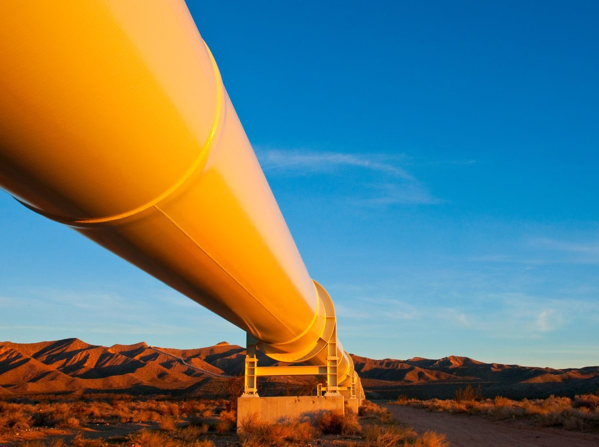 Above-ground pipeline crossing the Mojave desert at sunset